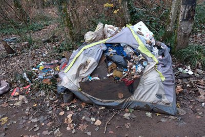 This old tent near the river became a trash receptacle