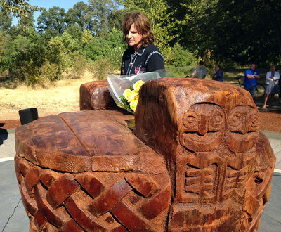 Amy Ray of Indigo Girls examines the native design of the memorial play structure. Photo credit: Camilla Mortensen.
